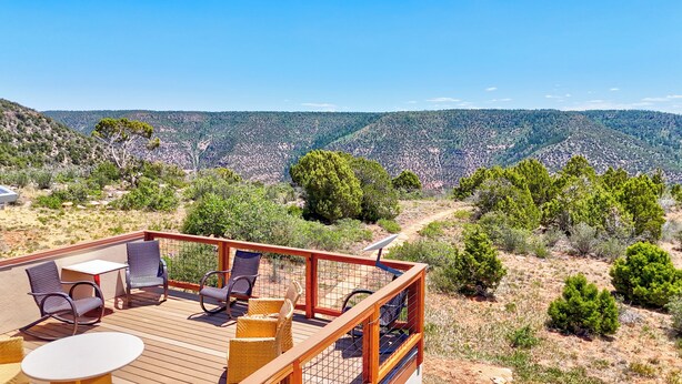 A deck with outdoor seating and a scenic mountain view. - Stunning Canyon-Rim Retreat on the Dolores River in beautiful SW Colorado. (Dove Creek)