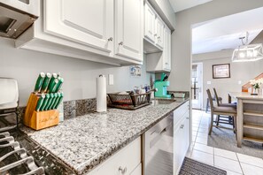 Enjoy cooking in this well-equipped kitchen with an oven, stainless steel range hood, and large island with sink.