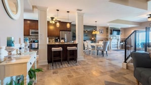 A spacious living area with a kitchen, dining area, and a staircase leading to an upper level. - Beach front Condo with amazing water views! (Indialantic)