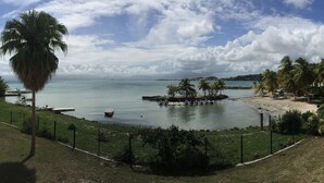 A coastal view with a marina, palm trees, and a beach. - Comfortable studio apartment in Le Gosier (Le Gosier)