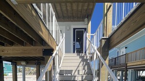 A wooden staircase leading to a door, surrounded by railings and wooden beams. - Steps away from the sugar white sands and blue water!! (Fort Myers Beach)
