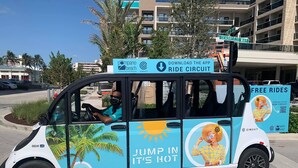 Promotievoertuig met advertenties voor Pompano Beach Circuit en gratis ritten.