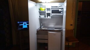 Una cuina compacta amb microones integrat, un rentaplat i un frigorífic.