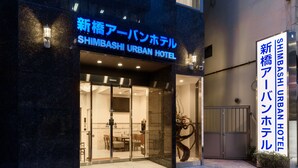 The exterior of the Shimbashi Urban Hotel with a modern facade, large glass entrance, and a decorative sculpture outside. - Shimbashi Urban Hotel (Tokyo)
