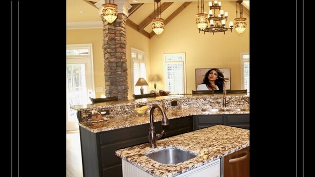 A kitchen with granite countertops, a stainless steel sink, and a stone pillar. - Beautiful -Spacious Home @ Lake Lanier (Flowery Branch)