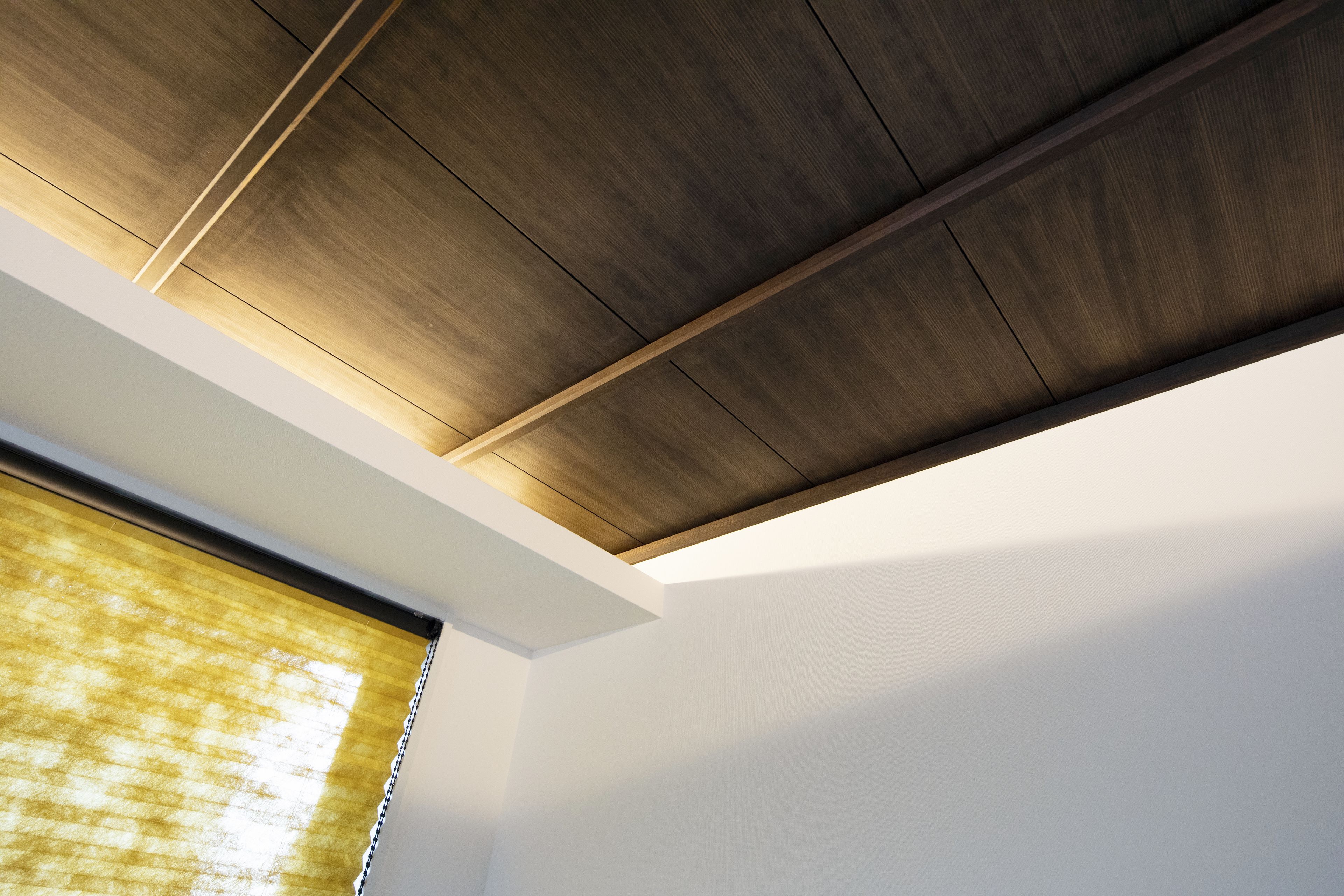 Un techo moderno con paneles de madera y detalles blancos.