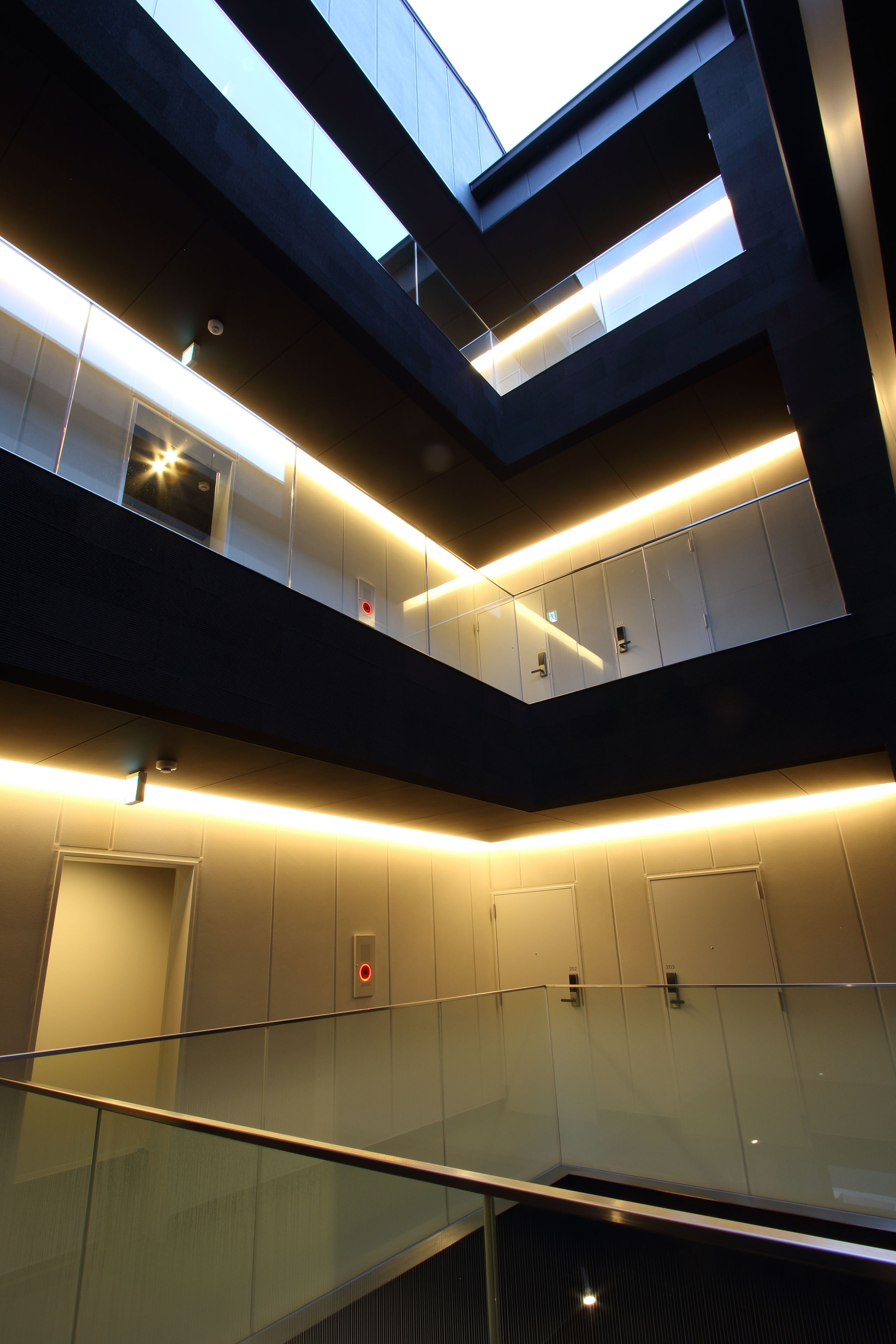 A multi-level interior with glass railings and modern lighting.