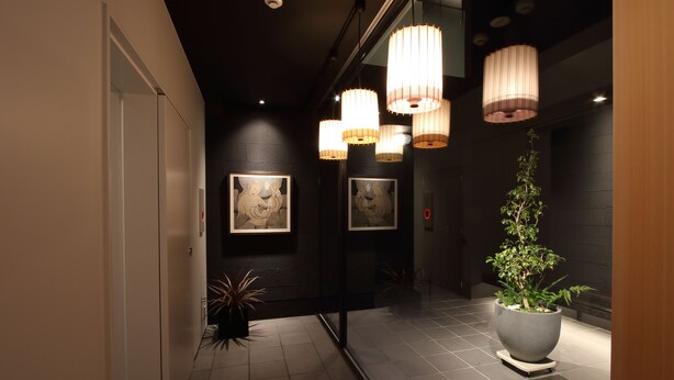 Un pasillo con decoración moderna, que incluye obras de arte colgadas en la pared y una planta grande en maceta.