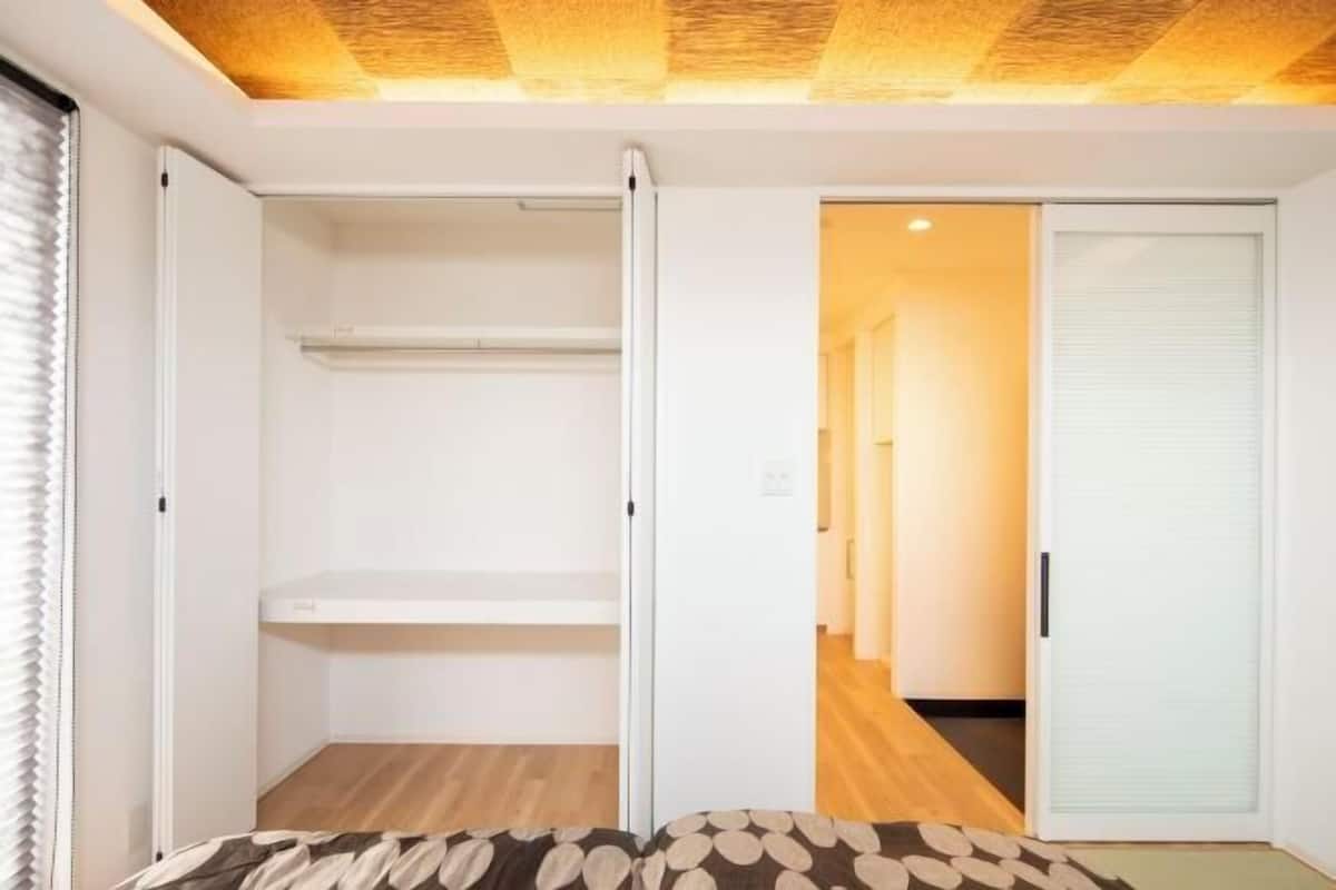 A room with a bed, a wardrobe, and a sliding door leading to a hallway.