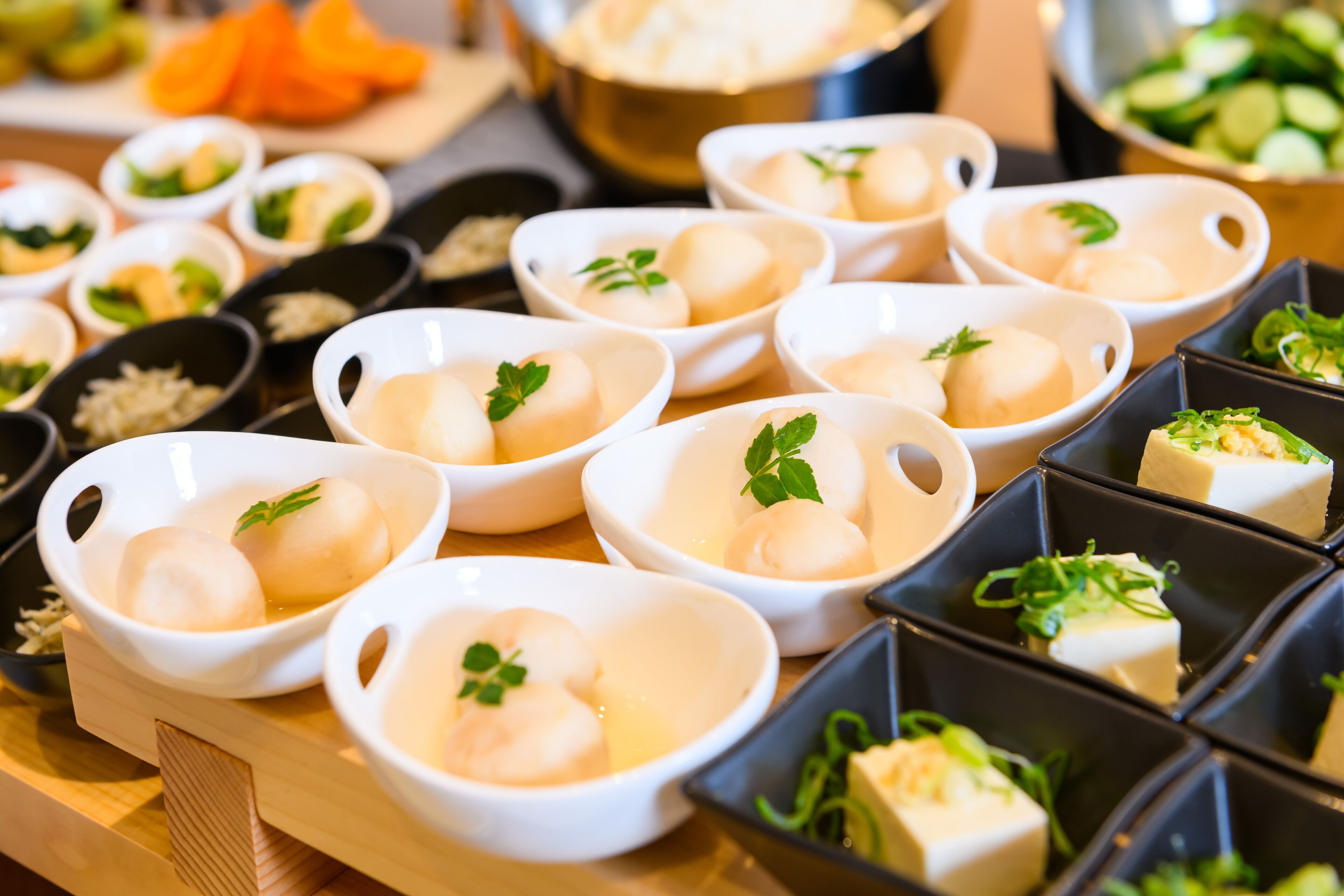 Une variété d’aliments disposés sur une table, notamment des bols de raviolis et d’autres plats.