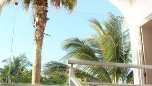 A balcony with a view of palm trees and a clear sky. - "Escape to Paradise: Suites Lorens in the Heart of Isla Mujeres" (Isla Mujeres)