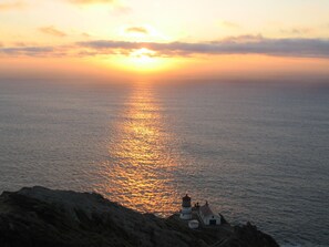 A coastal sunset with a lighthouse on a rocky outcrop. - Point Reyes Station Vacation Home: Close to Town (Point Reyes Station)