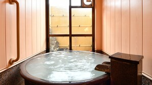 A wooden room with a hot tub, wooden benches, and a window with a view of a fence. - Ryokan Tamura (Kusatsu)