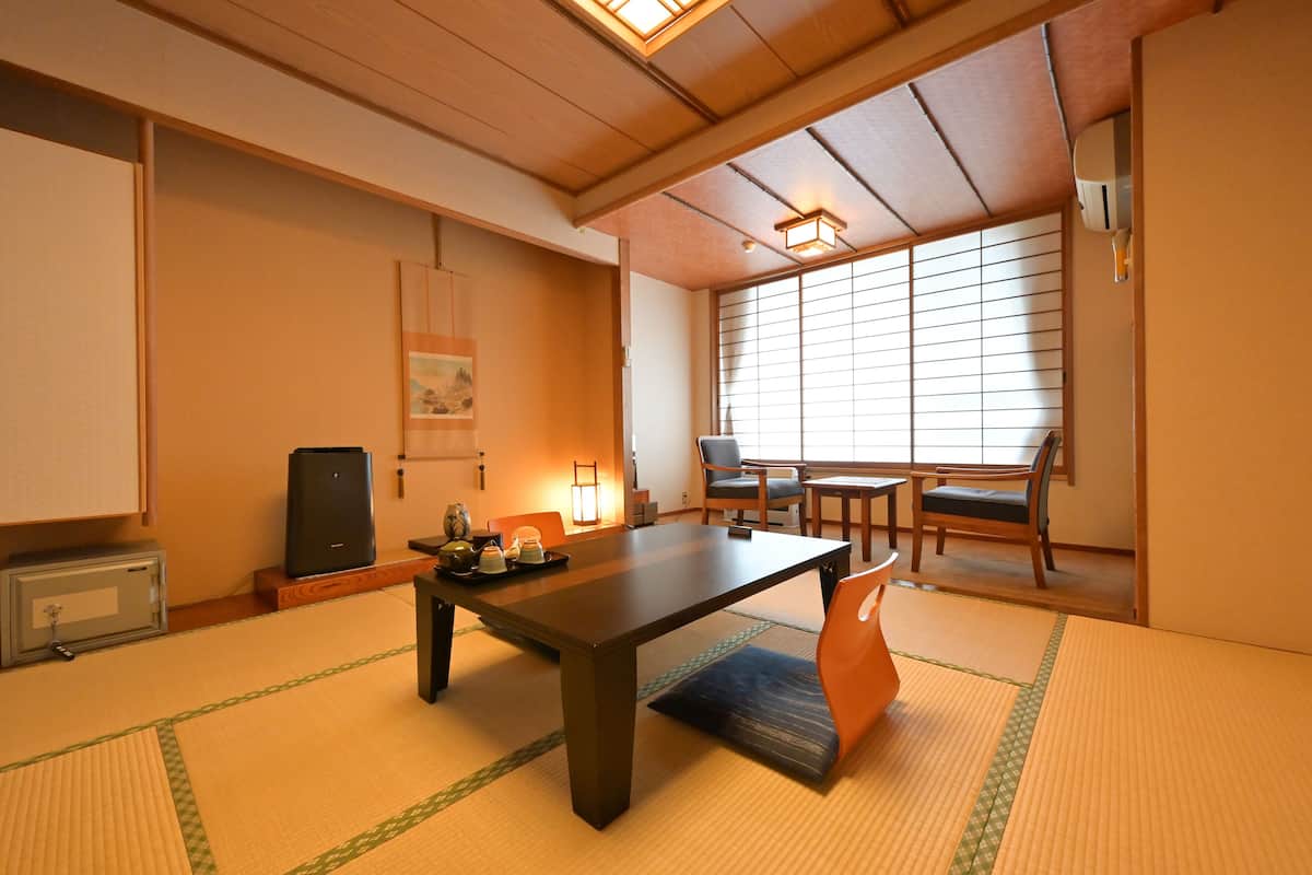 A traditional Japanese room with tatami flooring, a low table, and sliding doors.