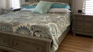 Une chambre à coucher avec un grand lit, deux tables de chevet et une petite table de nuit.