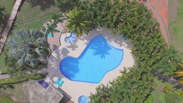 Surrounded by lush tropical vegetation, this resort features a central oval-shaped pool.