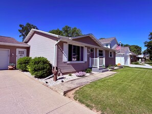 A single-story house with a front porch, a garage, and a well-maintained lawn.