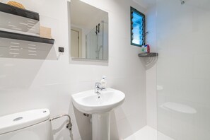 Ein Badezimmer mit Waschbecken, Toilette, Dusche und Spiegel.