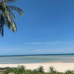 Trên bãi biển, cát trắng, ghế dài tắm nắng, dù trên bãi biển
