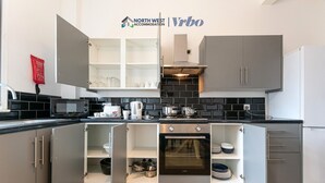 Une cuisine moderne avec des meubles gris, un four encastré et un four à micro-ondes.