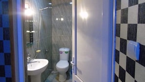 Ein Badezimmer mit einem weißen Waschbecken, einer Toilette und einer Dusche.