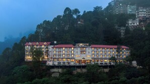 A multi-story hotel with a red roof, situated on a hillside surrounded by dense forest. - 8fold by LaRiSa, Shimla (Shimla)