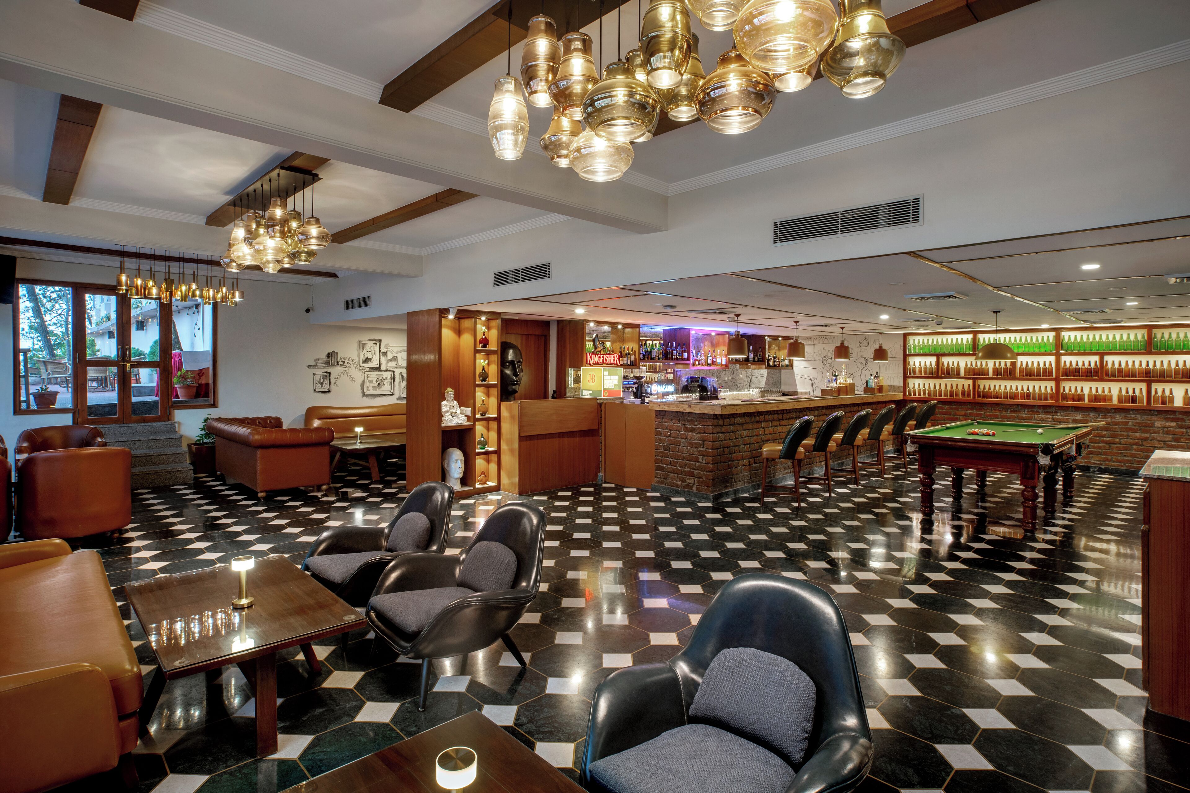 A bar area with a pool table, seating, and a bar counter.