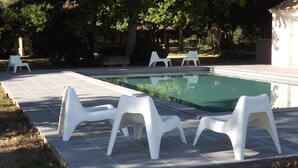 A swimming pool area with white plastic chairs arranged around it. - Cottage studio in the countryside (Cavaillon)