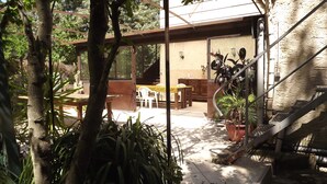 A covered patio area with outdoor furniture, potted plants, and a staircase leading to an upper level. - Cottage studio in the countryside (Cavaillon)