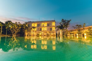 Ett stort hotell med flera våningar, där en swimmingpool syns tydligt på förgrunden.