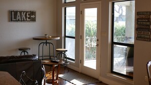 Ein gemütliches Zimmer mit Holzbalkendecke, einem großen Fenster, einer Tür und einem Schild an der Wand.