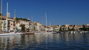 A marina with boats docked along the waterfront, surrounded by historic buildings with balconies and a clock tower. - Bright, air-conditioned studio with garden terrace, in the heart of Cannes (Cannes)