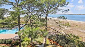 A pool area with a view of the beach and ocean.