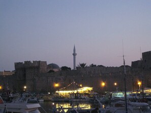 Boats docked at the marina, with a historic mosque in the background.