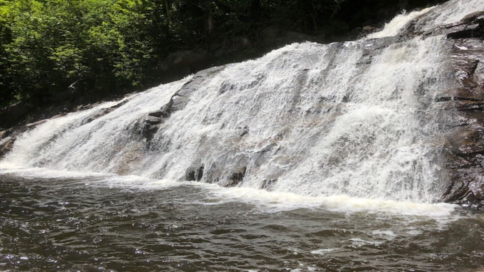 A waterfall cascading over a rocky cliff into a river.