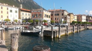 A marina with boats docked, a waterfront promenade, and buildings with traditional architecture. - # 208 Casa Allegro for 4 people, pool, lake view (Gardola)