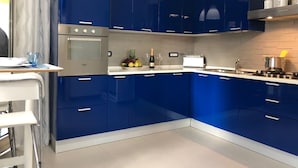 A modern kitchen with blue cabinets, a stainless steel oven, and a white countertop. - A newly renovated, stylish 2 bedroom apartment with amazing sea view (Nerano)