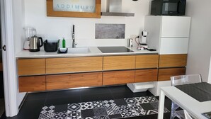Een moderne keuken met een houten kastje, een spoelbak, een magnetron en een koffieapparaat.