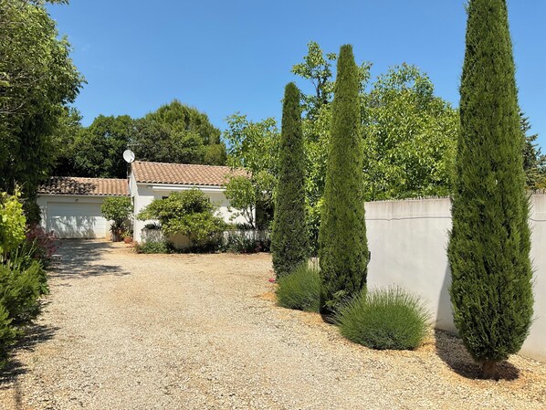 A gravel driveway leading to a white building with a tiled roof. - 10 minutes walk - air-conditioned (Uzès)