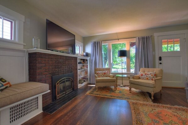 Télévision, cheminée, lecteur de DVD, livres