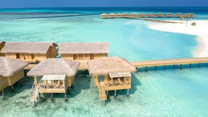 Overwater bungalows with thatched roofs, a wooden walkway, and a clear turquoise sea. - You & Me Maldives - Adults Only - Premium All-Inclusive (Uthurumaafaru)