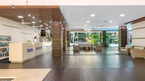 A reception area with a 'tours' desk, wooden flooring, and a view of the outdoors. - Lxry 2 bed Apt-Sea and Mountain View (Palm Cove)