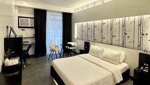 Una habitación de hotel moderna con una cama grande, un escritorio y una silla.