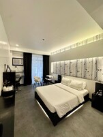 Una habitación de hotel moderna con una cama grande, un escritorio y una silla.