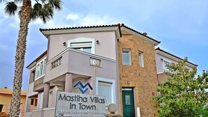 A multi-story building with a sign reading "Mastihas Villas in Town" indicating luxury self-catering accommodations. - Mastiha Villas in Town (Chios)