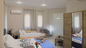 A modern hotel room with a single bed, a chair, a desk, and a mirror. - Mastiha Villas in Town (Chios)