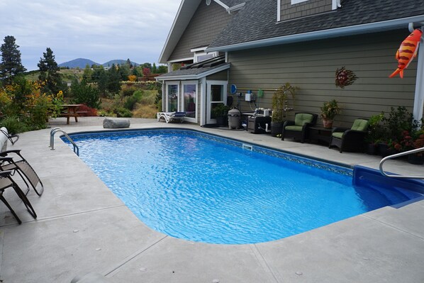 A swimming pool with a patio area, outdoor furniture, and a view of the surrounding landscape. - Dreams B&B - Crystal room (Summerland)