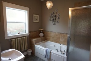 A bathroom with a bathtub, a sink, a window, and a decorative wall piece. - Dreams B&B - Crystal room (Summerland)