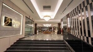 A hotel lobby with a reception desk, a chandelier, and a check-in counter. - Brzeen Hotel - Riyadh - فندق برزين الرياض (Riyadh)
