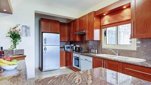 Eine moderne Küche mit Granit Arbeitsplatten, Edelstahlgeräten und Holzschränken.